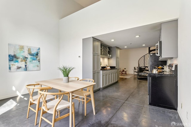 dining room with baseboards, concrete flooring, and recessed lighting