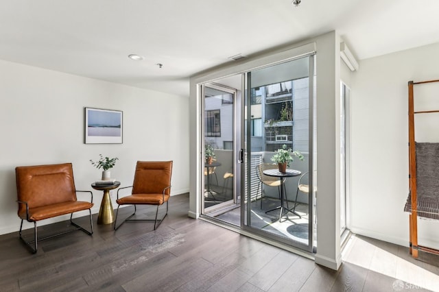 living area featuring baseboards, wood finished floors, and visible vents