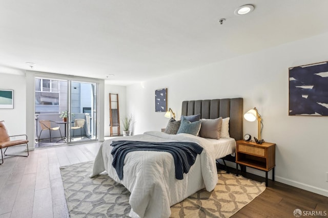 bedroom with wood-type flooring and baseboards