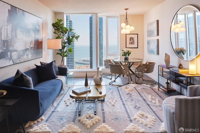 living room with a water view, a chandelier, and hardwood / wood-style flooring