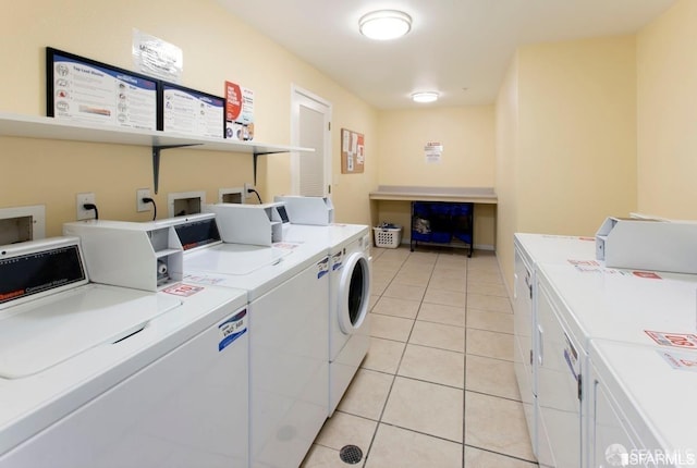 clothes washing area with light tile patterned flooring and washer and clothes dryer