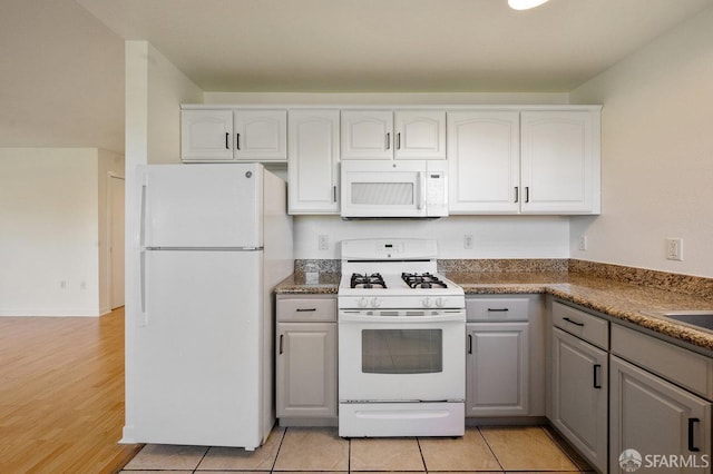 kitchen with white appliances, white cabinetry, light tile patterned floors, and gray cabinetry