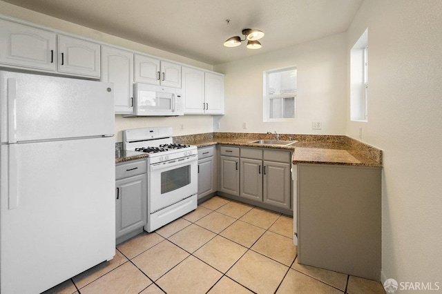 kitchen with white appliances, light tile patterned flooring, and sink