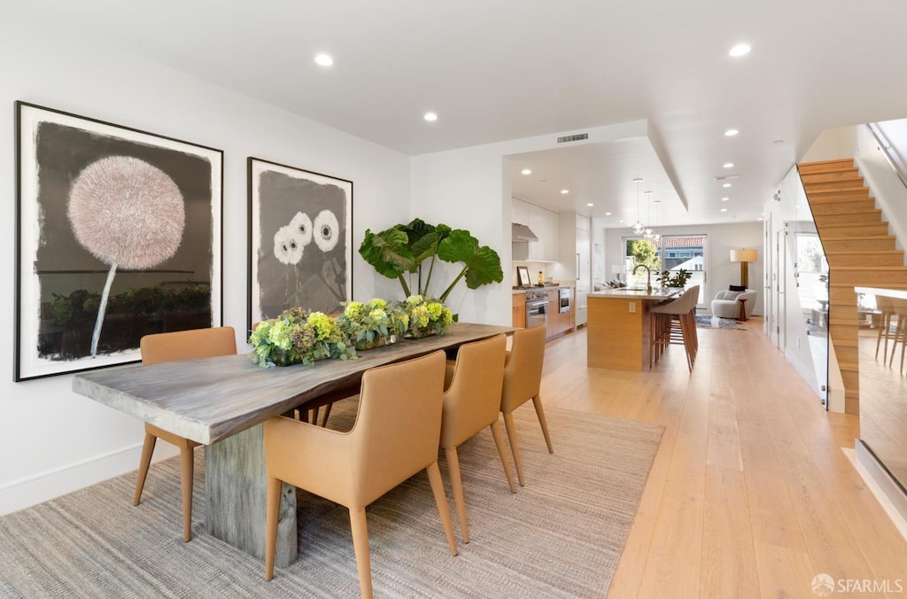 dining area with light wood-type flooring and sink