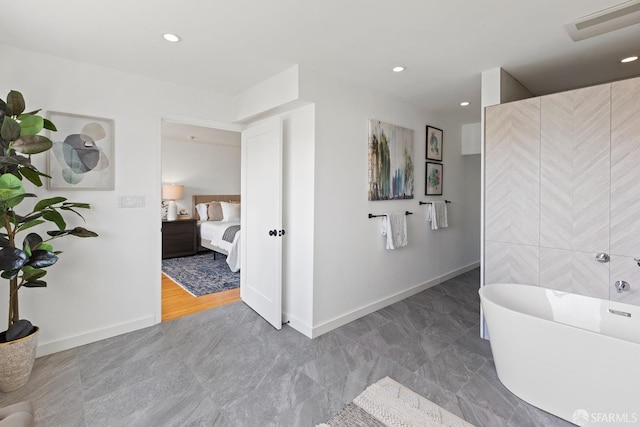 ensuite bathroom with a soaking tub, baseboards, and recessed lighting