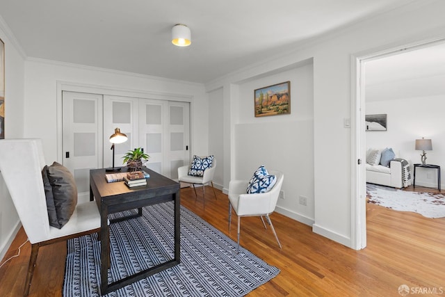 home office with wood finished floors, ornamental molding, and baseboards