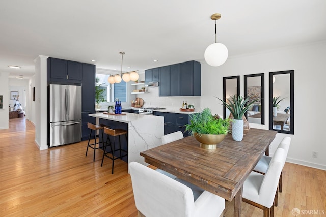 dining area featuring light wood-style flooring, baseboards, and recessed lighting