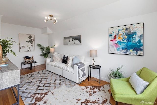 living room featuring wood finished floors, baseboards, and a chandelier