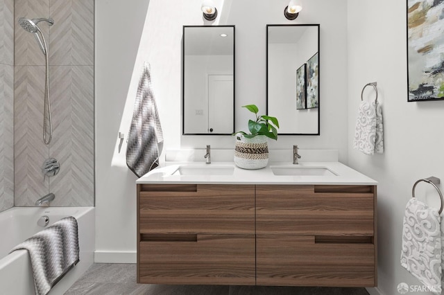 full bathroom with double vanity, shower / tub combination, and baseboards