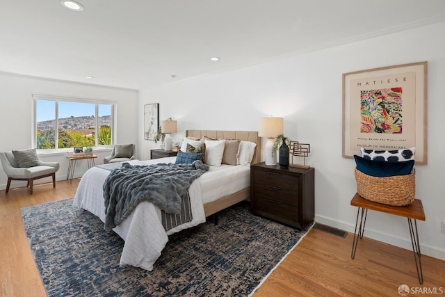 bedroom featuring wood finished floors, baseboards, and recessed lighting
