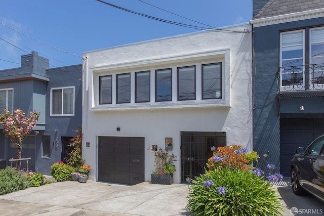 view of front of home featuring stucco siding, an attached garage, and driveway