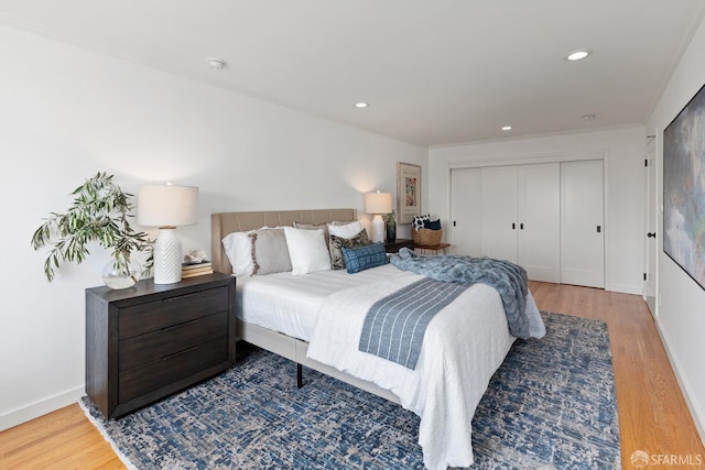 bedroom featuring wood finished floors, a closet, recessed lighting, and baseboards