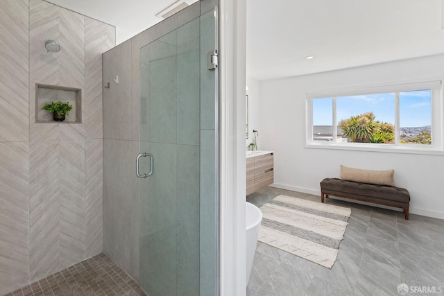 full bath with a stall shower, vanity, and baseboards
