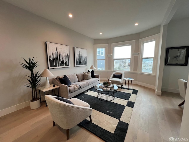 living area featuring light wood-style flooring, recessed lighting, and baseboards