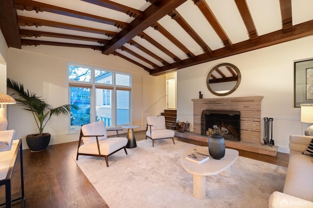 living area with vaulted ceiling with beams, a fireplace, and wood finished floors