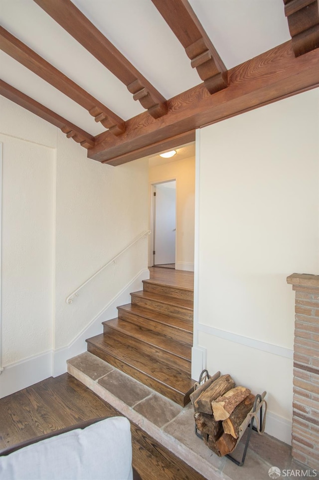 stairs featuring beam ceiling and baseboards