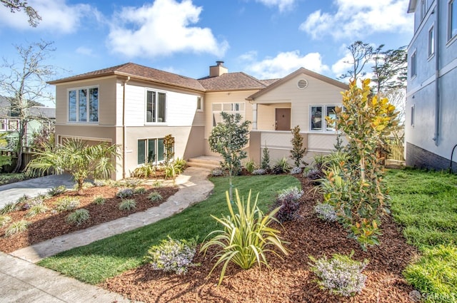 mediterranean / spanish home featuring concrete driveway, a chimney, an attached garage, a front lawn, and stucco siding