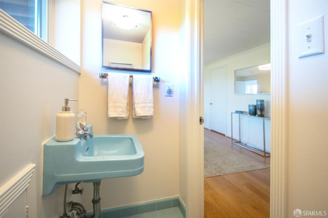 bathroom with crown molding and wood finished floors