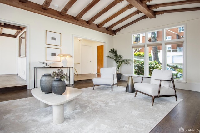 living area featuring vaulted ceiling with beams and wood finished floors