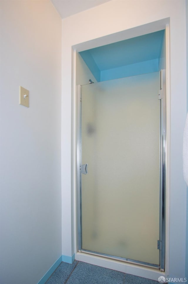 bathroom with a shower stall, baseboards, and speckled floor