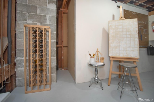 wine cellar featuring concrete block wall and finished concrete flooring