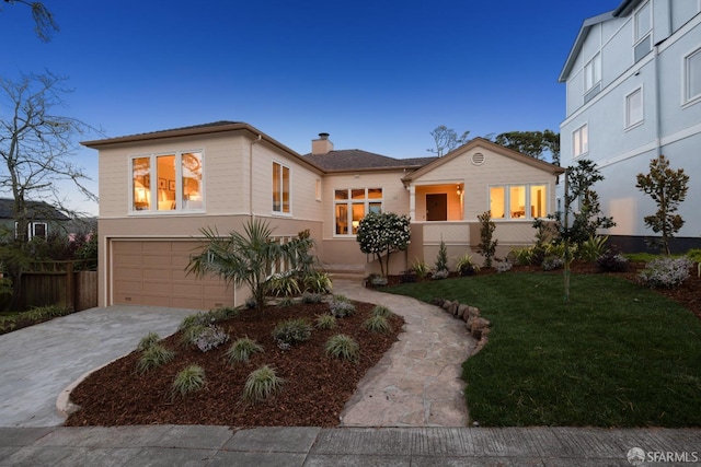 view of front facade featuring a garage, driveway, fence, a front lawn, and stucco siding