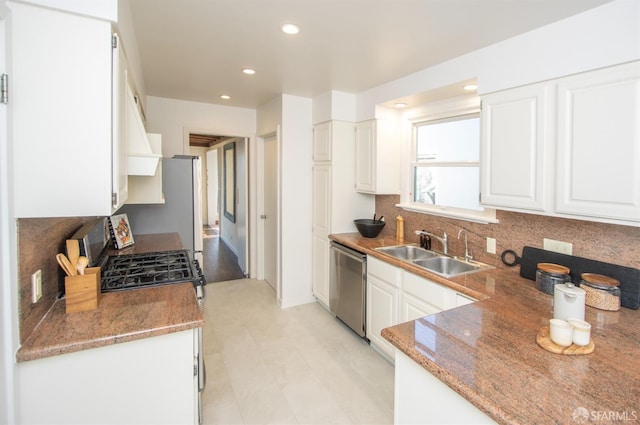 kitchen featuring tasteful backsplash, white cabinets, stainless steel appliances, a sink, and recessed lighting