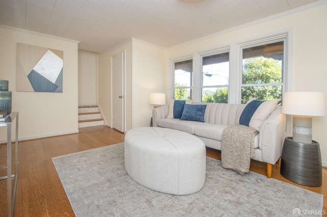 living area featuring stairway, wood finished floors, and crown molding