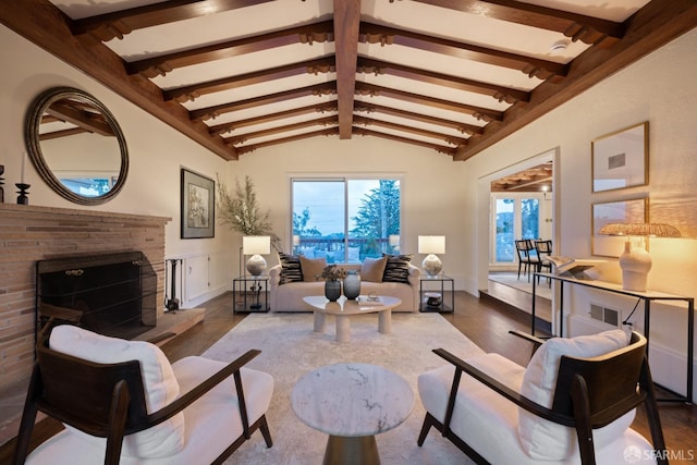 living room featuring a fireplace, vaulted ceiling with beams, and wood finished floors