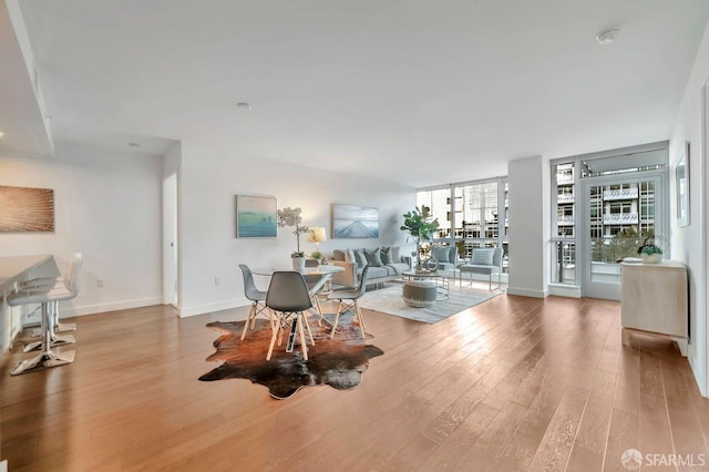 living room featuring light hardwood / wood-style floors, a wealth of natural light, and a wall of windows