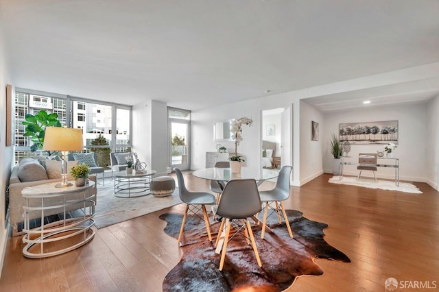 dining room featuring a wall of windows and wood-type flooring