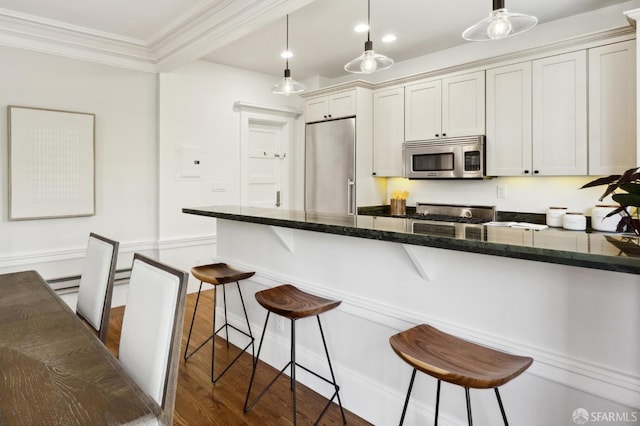 1856 Franklin St Unit 4, San Francisco, CA 94109 - kitchen with appliances with stainless steel finishes, a breakfast bar, crown molding, dark wood-type flooring, and decorative light fixtures