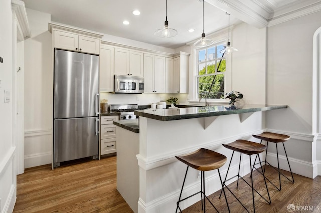 1856 Franklin St Unit 4, San Francisco, CA 94109 - kitchen with stainless steel appliances, a breakfast bar area, wood finished floors, dark countertops, and recessed lighting