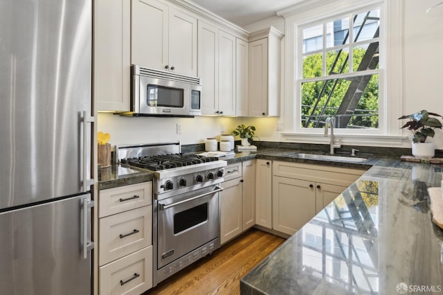 1856 Franklin St Unit 4, San Francisco, CA 94109 - kitchen with appliances with stainless steel finishes, wood finished floors, a sink, and dark stone countertops