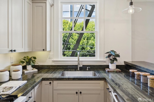 1856 Franklin St Unit 4, San Francisco, CA 94109 - kitchen with a sink, dark stone counters, pendant lighting, and white cabinets