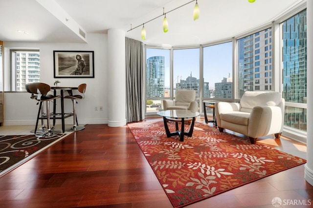 interior space featuring rail lighting, hardwood / wood-style floors, and a wall of windows