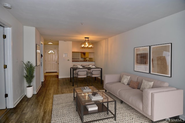 living room featuring baseboards, wood finished floors, and a chandelier
