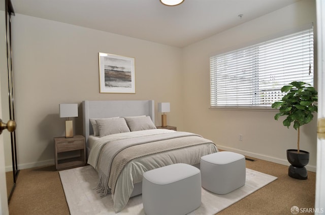 bedroom featuring baseboards and light carpet