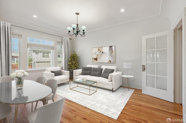 living area with light wood-style flooring, baseboards, a notable chandelier, and recessed lighting