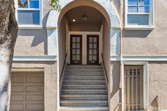 doorway to property featuring french doors and stucco siding