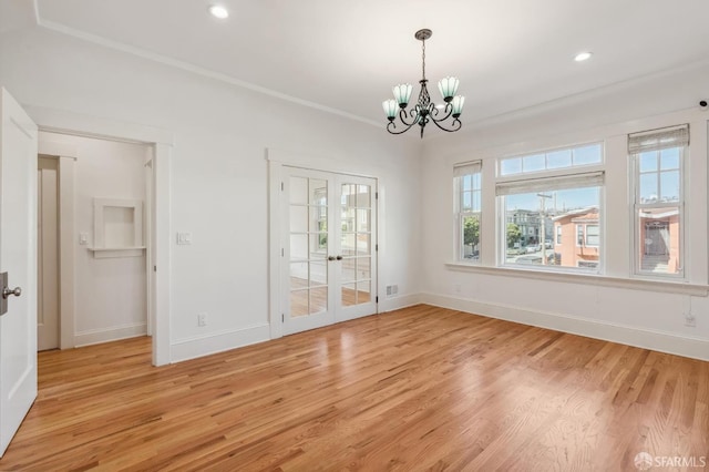 unfurnished dining area with light wood-type flooring, an inviting chandelier, baseboards, and french doors