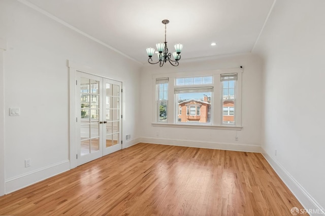 unfurnished dining area with light wood-style flooring, ornamental molding, baseboards, and french doors