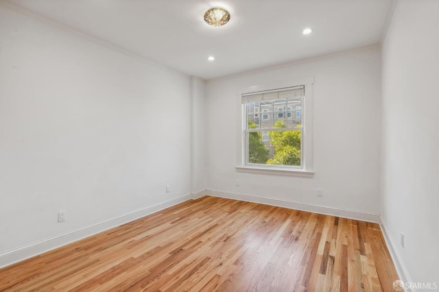 spare room with light wood finished floors, baseboards, and recessed lighting