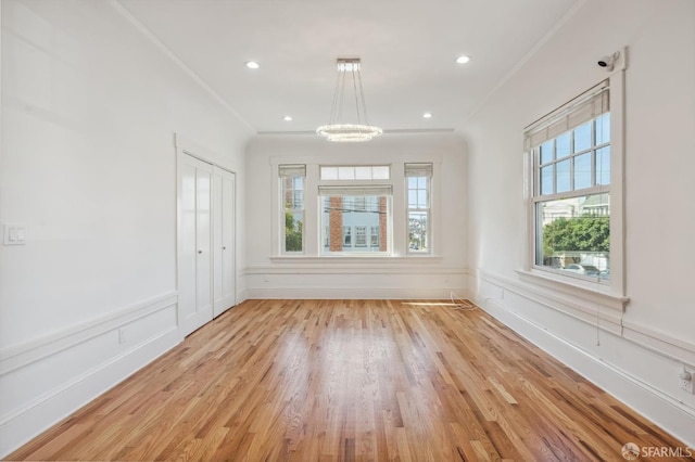 unfurnished room with a wainscoted wall, light wood-style flooring, a decorative wall, and recessed lighting