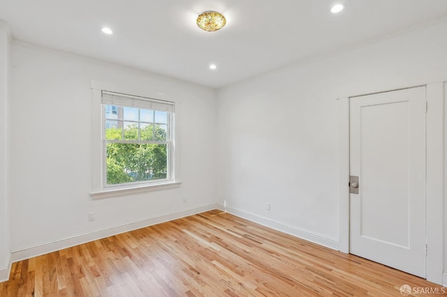 empty room with recessed lighting, light wood-type flooring, and baseboards