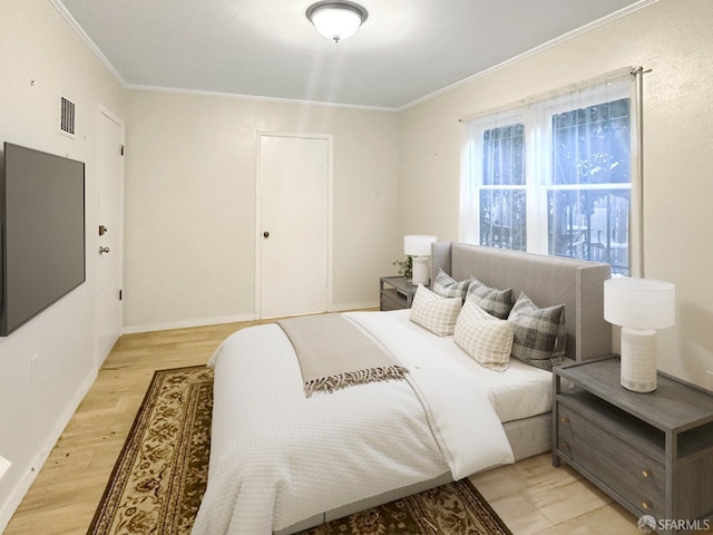 bedroom featuring light hardwood / wood-style floors and crown molding