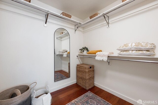 walk in closet with dark wood-type flooring