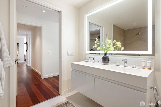 bathroom with vanity, hardwood / wood-style floors, and tiled shower