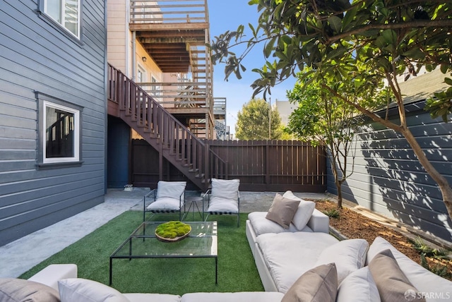 view of patio with outdoor lounge area, stairway, and a fenced backyard