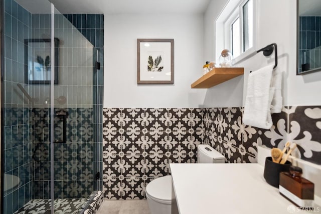 full bathroom featuring wainscoting, a stall shower, toilet, and vanity